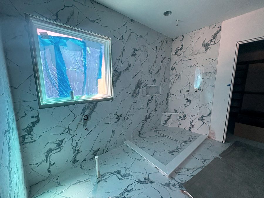 Marble-look tile bathroom with a curbless shower
